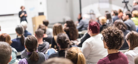 female speaker in auditorium with audience